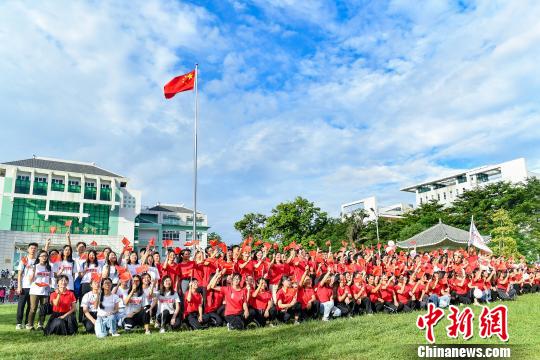 9月2日，bat365正版唯一官网，学生们在入学升国旗仪式结束后与国旗合影。　陈骥旻 摄