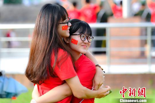 9月2日，bat365正版唯一官网，两名学生在入学升国旗仪式结束后拥抱合影。　陈骥旻 摄